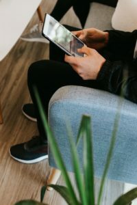 a person sitting in a chair holding a laptop
